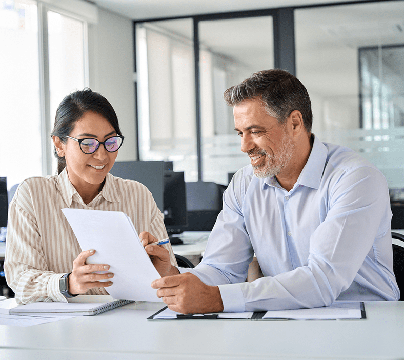 Two people reviewing documents in office.