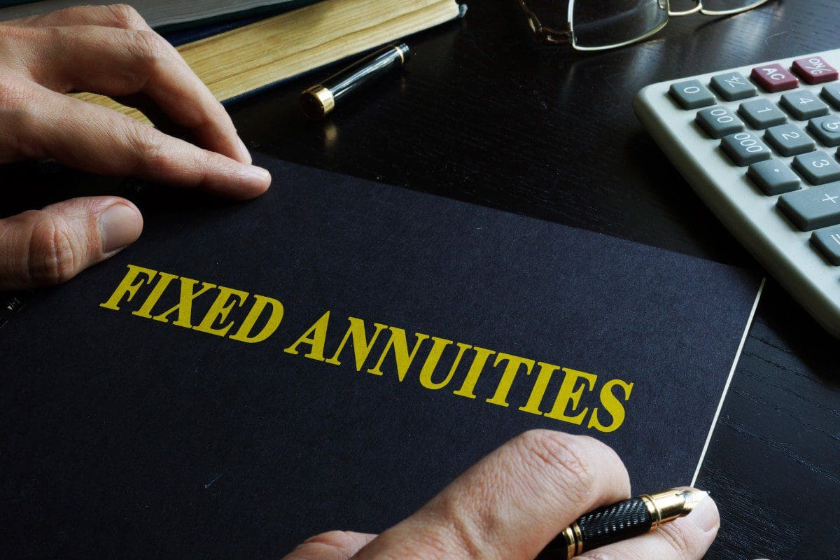 Hands holding a "Fixed Annuities" folder.