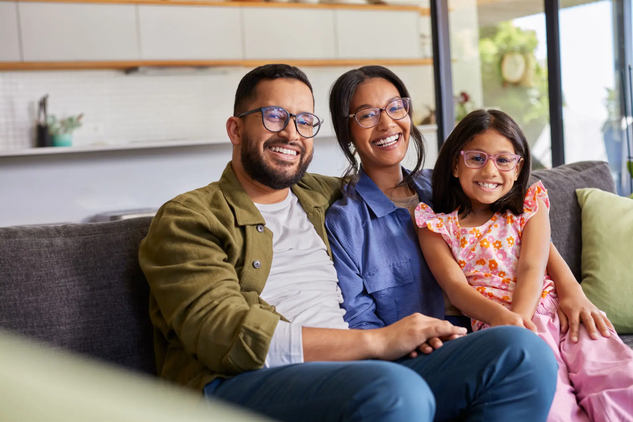 Happy family smiling together on a sofa.