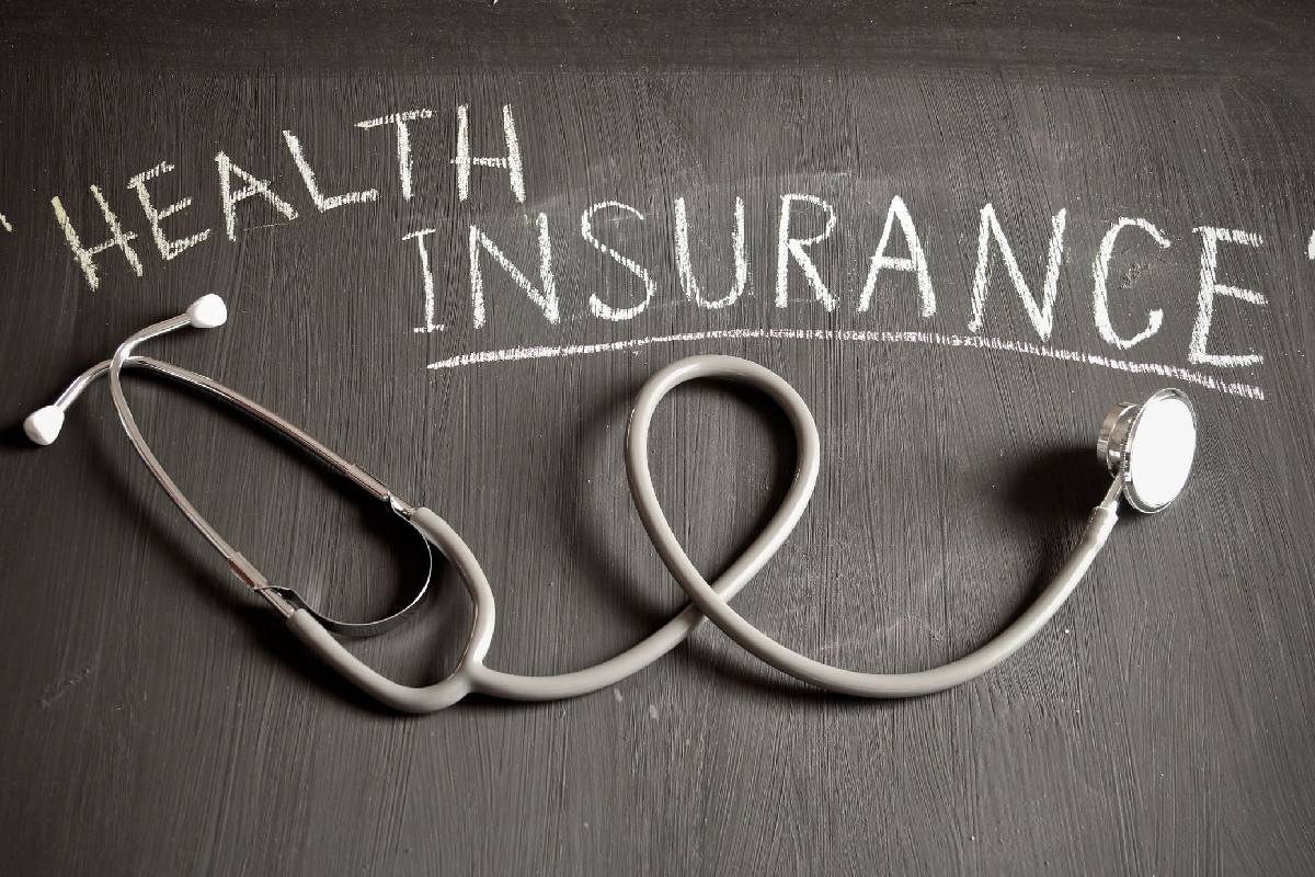 Stethoscope with "Health Insurance" chalk writing.